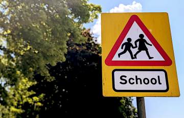 School crossing warning sign with children silhouettes