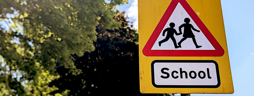 School crossing warning sign with children silhouettes