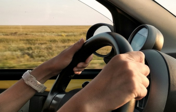 person with white watch driving car