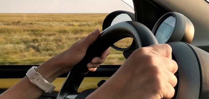 person with white watch driving car